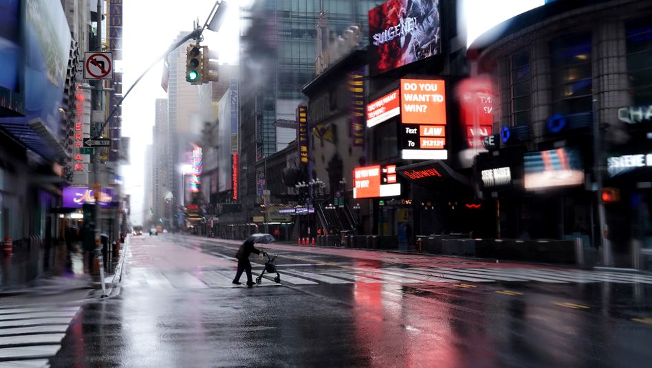 A person with a walker crosses 42nd Street in a mostly deserted Times Square following the outbreak of Coronavirus disease (COVID-19), in the Manhattan borough of New York City, New York, U.S., March 23, 2020. REUTERS/Carlo Allegri