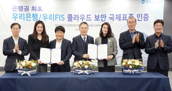  * 우리은행(은행장 이원덕)과 우리에프아이에스(대표 고정현)가 6일 마포구 소재 우리에프아이에스 본점에서 ISO 27017 국제 표준 클라우드 보안인증 수여식을 진행했다. 고정현 우리은행 IT그룹 부행장 겸 우리에프아이에스 대표(가운데), 김백수 우리은행 정보보호그룹 부행장(왼쪽 세번째), 이소영 DNV BA 코리아 대표(왼쪽 두번째)가 관계자들과 기념촬영을 하고 있다