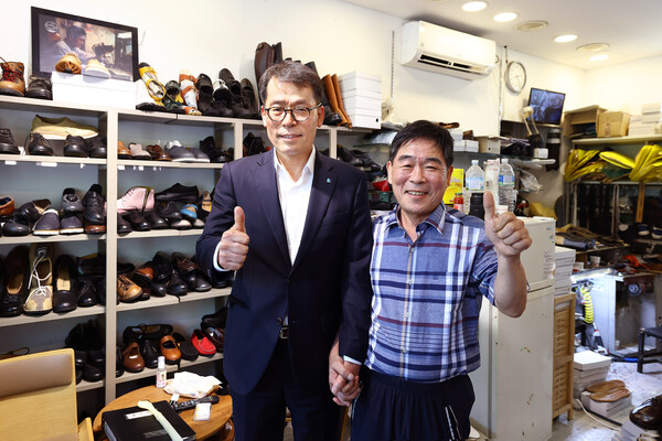김성태 IBK기업은행장(왼쪽)이 4일 서울 염천교 수제화거리를 찾아 고기황 이태리제화 대표(오른쪽)의 점포에서 수제화를 구입했다. [출처: IBK기업은행]