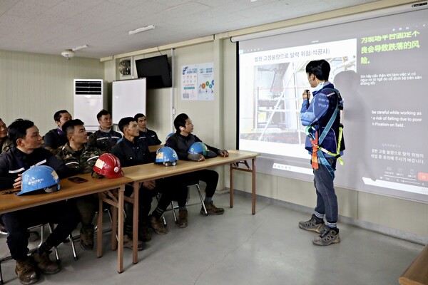GS건설 아파트 현장에서 ‘자이 보이스’를 활용해 다양한 국적의 외국인 근로자들에게 안전교육을 진행하고 있는 모습 (사진제공=GS건설)