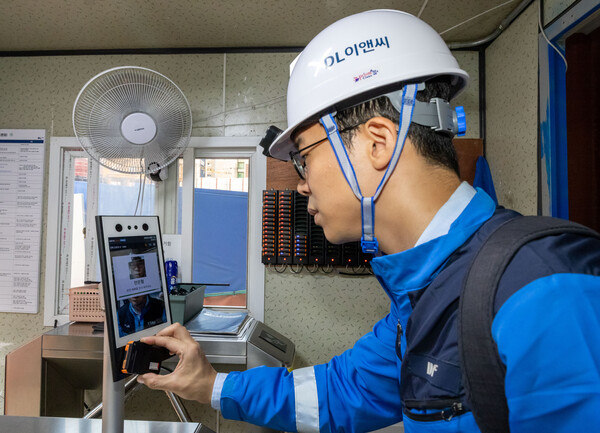 DL이앤씨 근로자가 안전삐삐를 지급받은 후 안면인식 시스템을 거쳐 현장에 출입하고 있다.(사진제공=DL이앤씨)