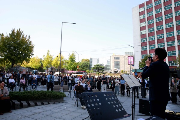 태광그룹 장애인 표준사업장 '큰희망'에서 환경지원 직무로 근무하면서 하모니카 연주자로도 유명세를 떨치고 있는 이현명 씨가 광화문 랜드마크 ‘해머링맨’ 앞에 마련된 야외무대에서 연주하고 있다. (사진제공=태광그룹)