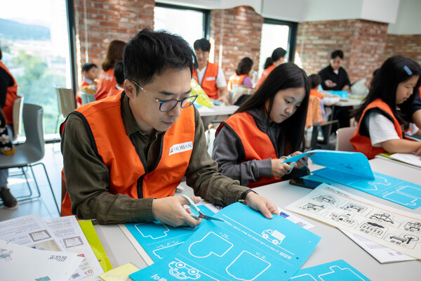 홍반사랑나눔이 봉사활동에 참여한 임직원과 가족이 점자촉각교구재를 만들고 있다. (사진제공=호반그룹)