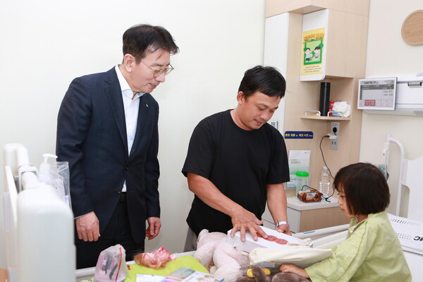 이재근 KB국민은행장이 심장병 수술을 받은 어린이와 부모에게 인형과 선물을 전달했다. [출처: KB국민은행]