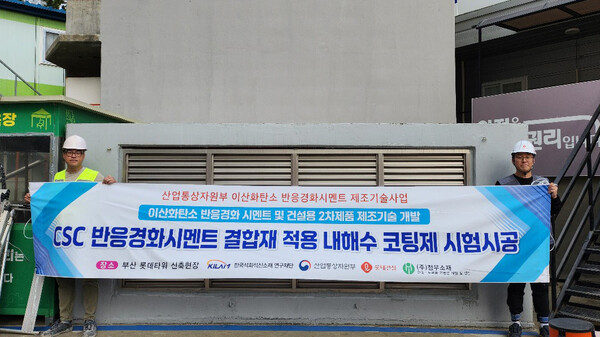 롯데건설 직원들이 부산 롯데타워 현장에서 이산화탄소 반응경화 시멘트를 활용한 코팅제를 시공하고 기념촬영을 하고 있다. (사진제공=롯데건설)