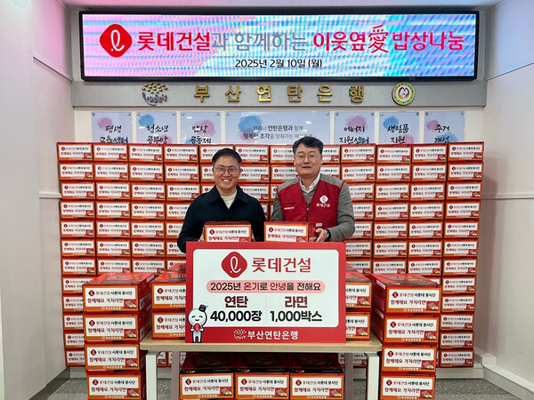 윤수준 롯데건설 영남지사장(오른쪽)이 강정칠 부산연탄은행 대표(왼쪽)에게 연탄과 라면 기증판을 전달했다. (사진제공=롯데건설)