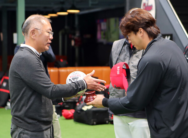 정의선 회장(왼쪽)이 주장 나성범 선수로부터 사인볼을 받고 악수하는 모습