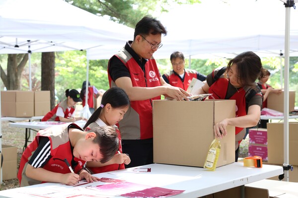 롯데건설 ‘샤롯데 봉사단’이 국가유공자 보훈가정을 위한 응원카드를 작성하고 기부물품을 포장하고 있다. (사진=롯데건설)