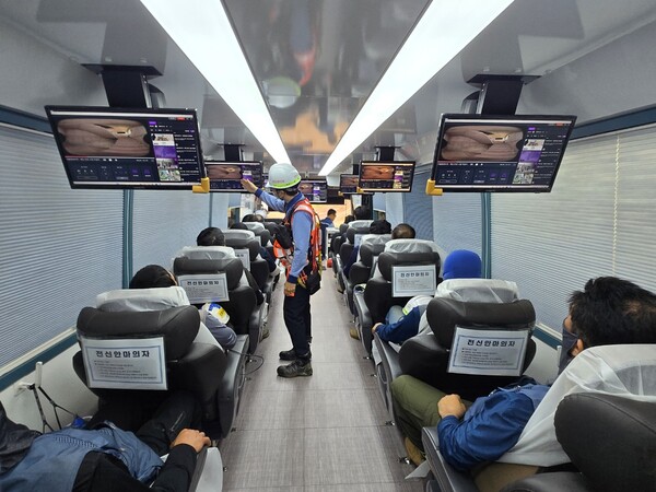 포스코이앤씨 현장 근로자들이 ‘찾아가는 이동 쿨쉼터’에서 더위를 피하며 휴식을 취하는 동안 안전영상도 함께 시청하고 있다.