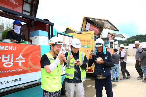 한화 건설부문이 건설현장 근로자들이 셈머 세이프트티 푸드트럭이 제공한 팥빙수를 먹고 있다. (사진제공=한화 건설)