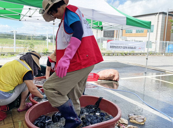 희망브리지 자원봉사자들이 수해로 오염된 의류를 빨래하고 있다(사진제공=희망브리지)