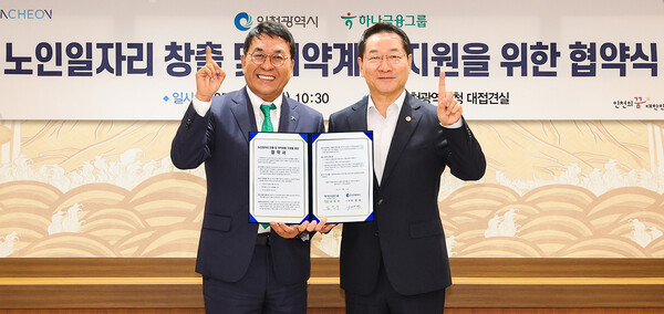  이날 협약식에 참석한 김진우 하나은행 중앙영업그룹 부행장(사진 왼쪽)이 유정복 인천시장(사진 오른쪽)과 함께 업무협약서를 들고 기념촬영을 하고 있다.