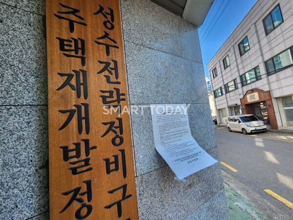성수1지구 조합 현판 옆에 붙은 부정행위 단속반 운영 안내문이 힘없이 바람에 휘날리고 있다. 출처=김종현 기자