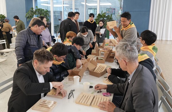 현대엔지니어링 '기프트하우스 플랜비: 벌, 집을 짓다' 전시회에서 참석자들이 야생벌집을 만들고 있다.