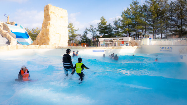 스플라스 리솜 고객들이 스플라스 스파&워터파크 야외 파도풀 아쿠아스톰에서 온천 파도를 즐기며 물놀이를 하고 있다. (사진제공=호반호텔앤리조트)